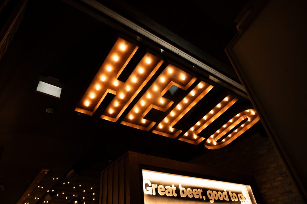 Interior decor of Brewco featuring a "hello" neon light and "great beer, good to go" signage.