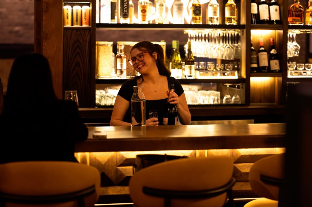 Bartender preparing drinks behind the Brewco bar