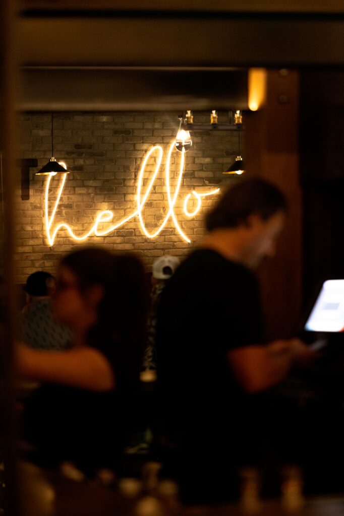 Neon hello sign and booth seating at Brewco